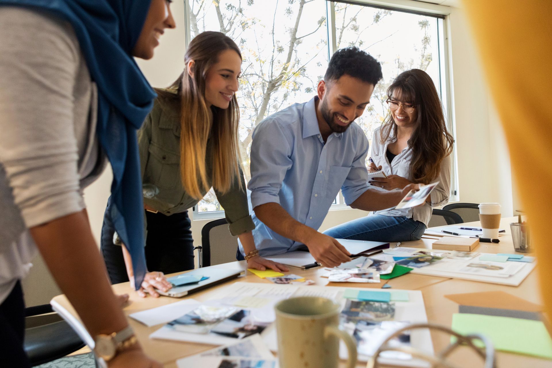 A group of people are sitting around a table looking at papers.