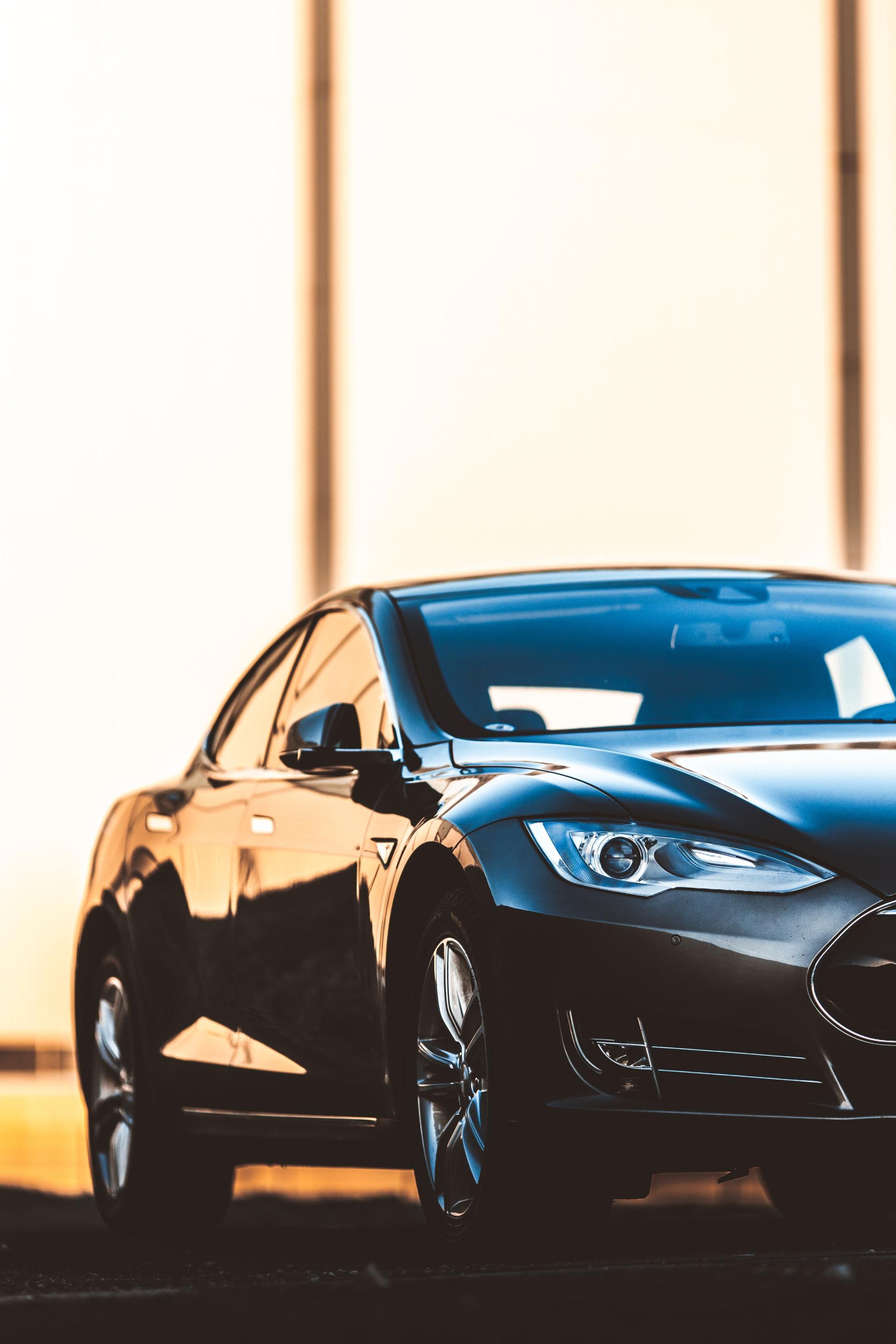 A black tesla model s is parked in front of a building.