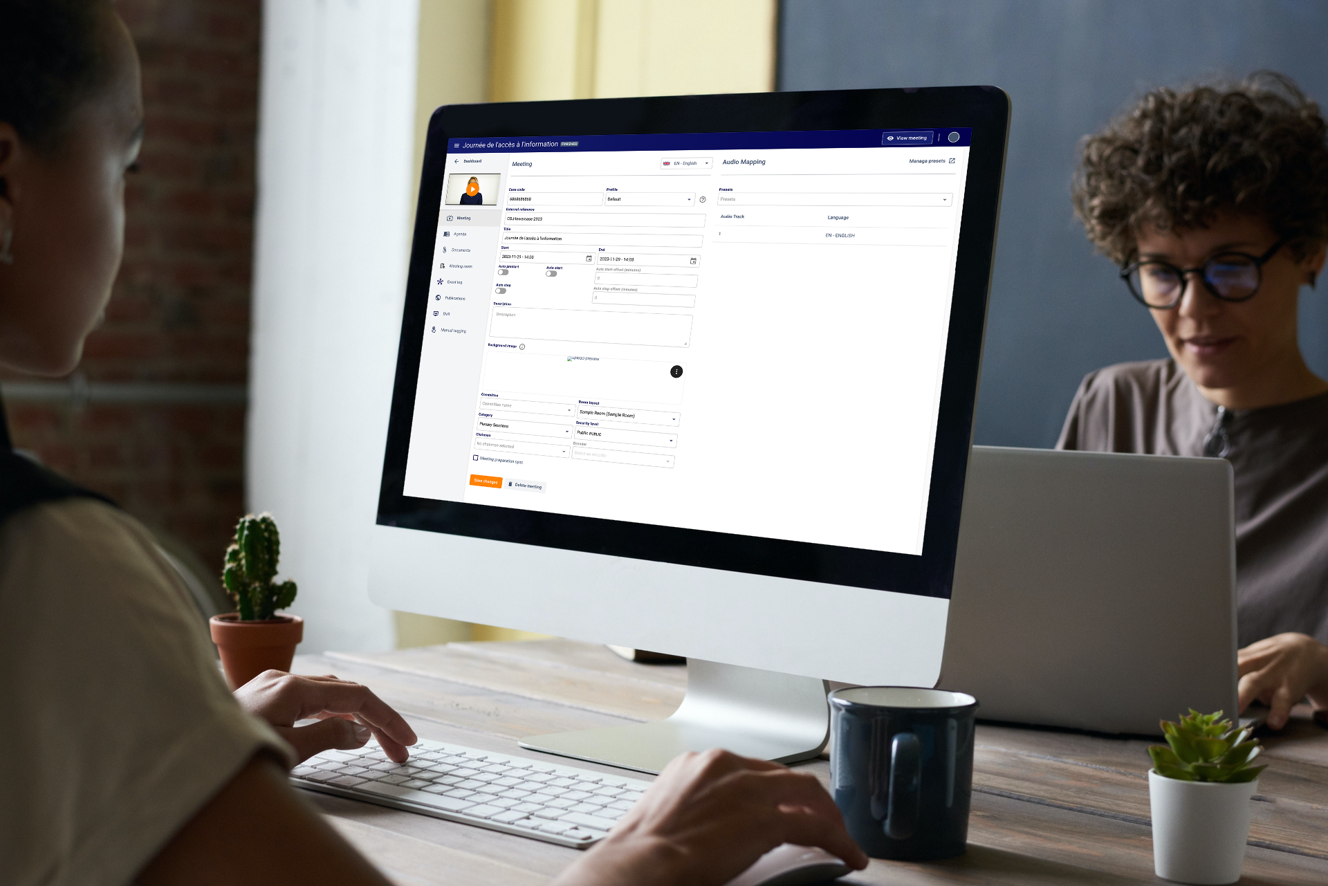 Two woman working behind computers one of them is user the arbor platform