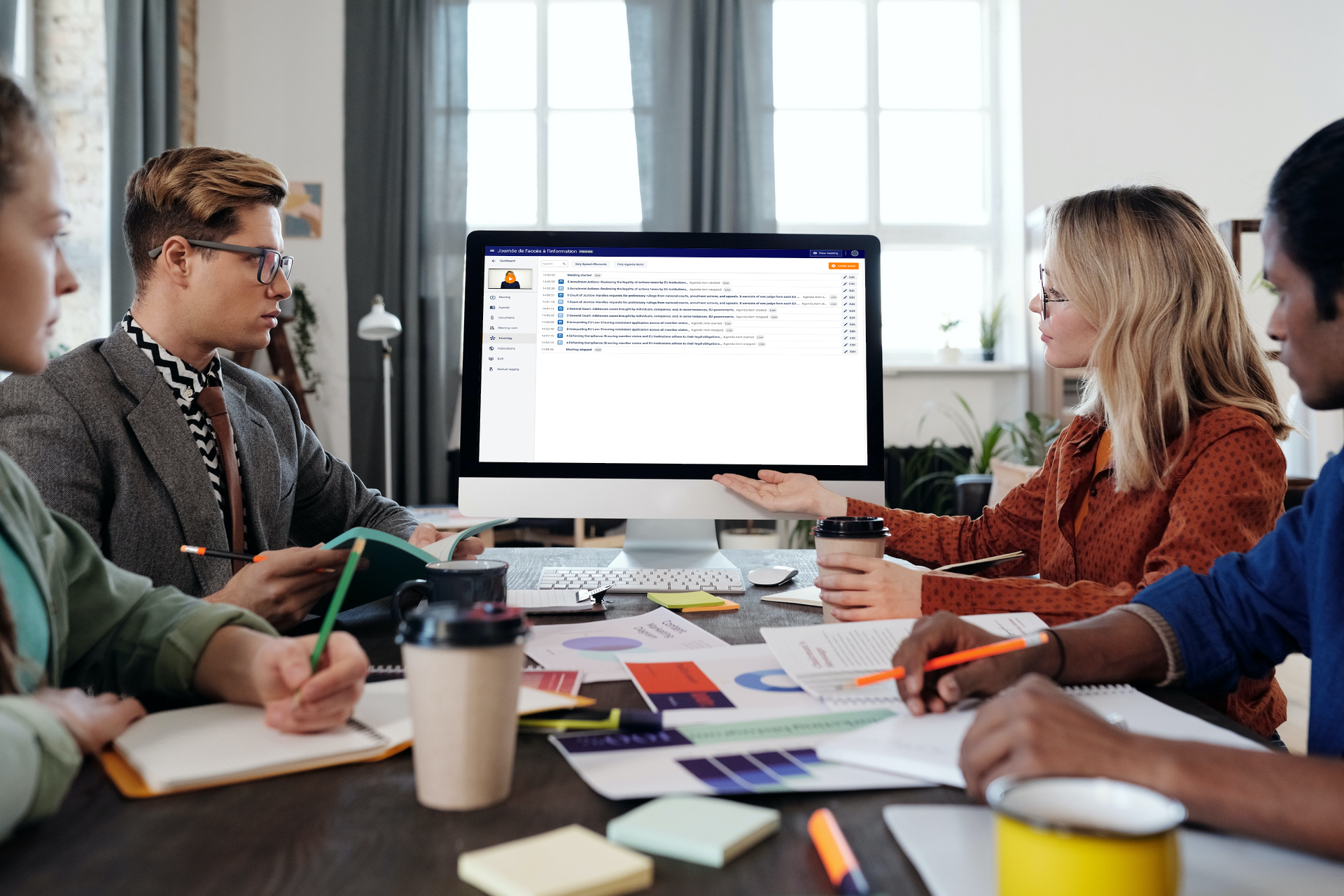 A group of four office sitting behind the same desk