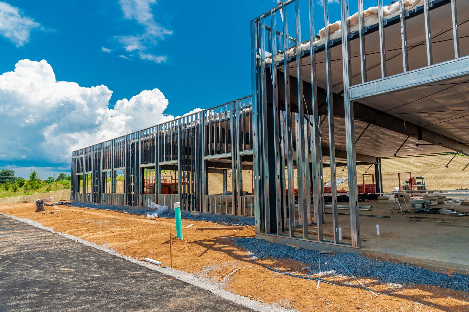 Steel-framed commercial building under construction on a clear day.