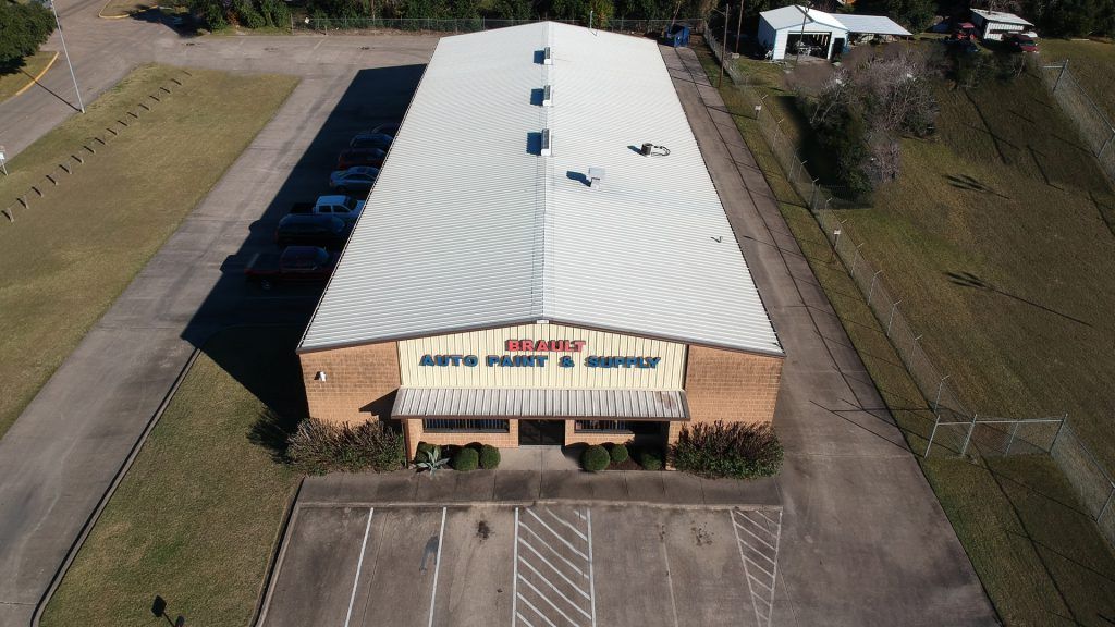 Aerial view of a commercial building with a metal roof, labeled 