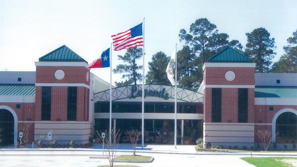 Building with brick facade, flags, and glass entrance.