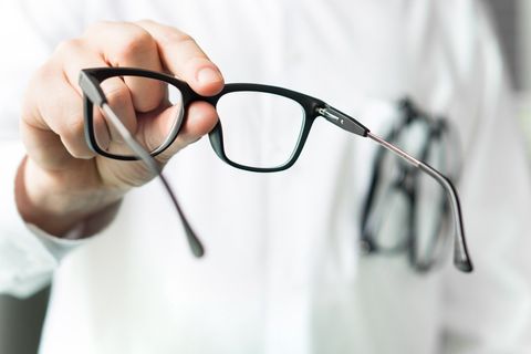 Optician Holding Eyeglasses — Villa Park, IL — James M. Saul OD
