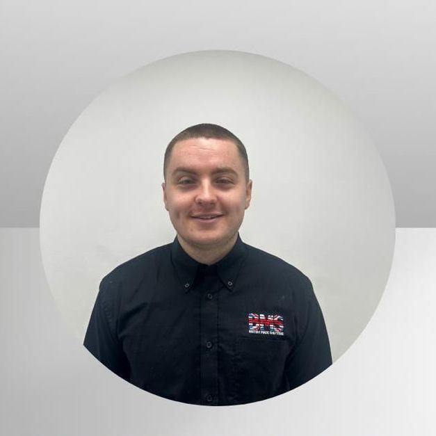 A man in a black shirt is standing in a circle and smiling.