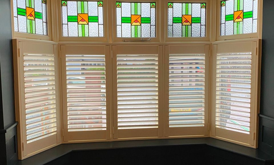 A bay window with shutters and stained glass windows