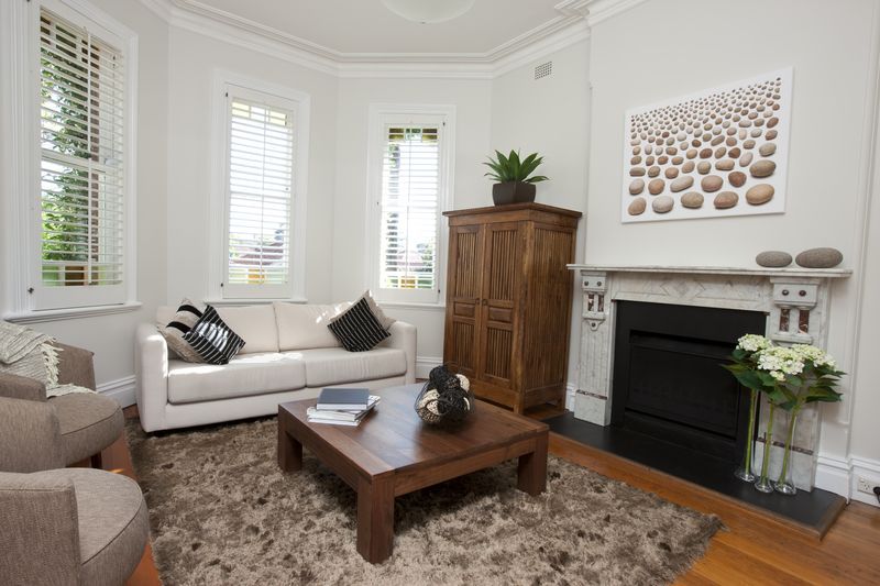 A living room with a white couch and a fireplace