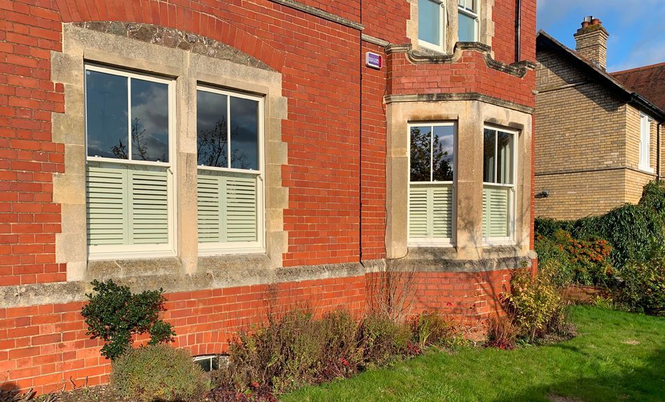 A red brick house with white windows and shutters