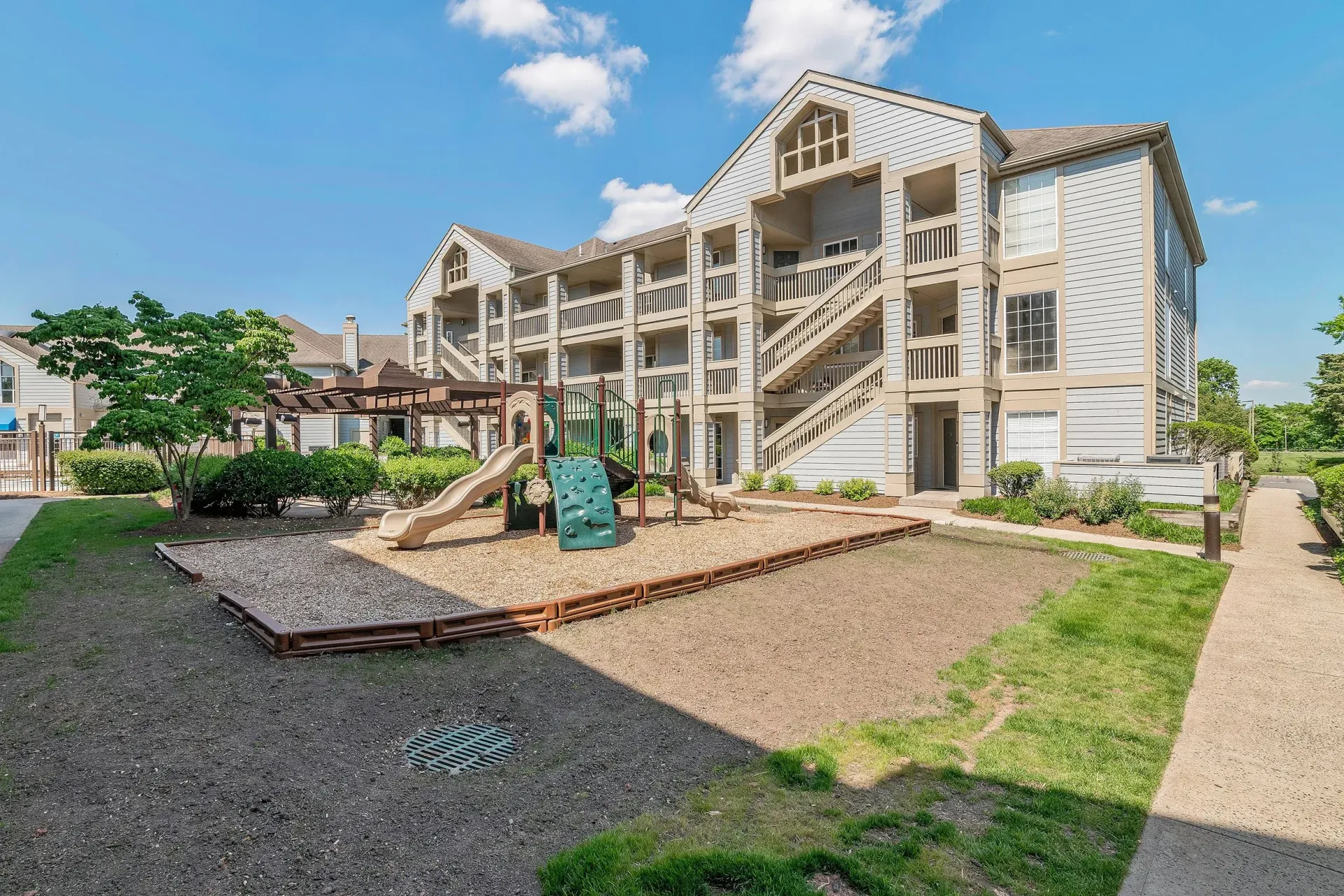 A large apartment building with a playground in front of it.