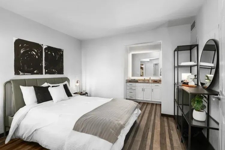 A bedroom with a large bed and a bathroom.