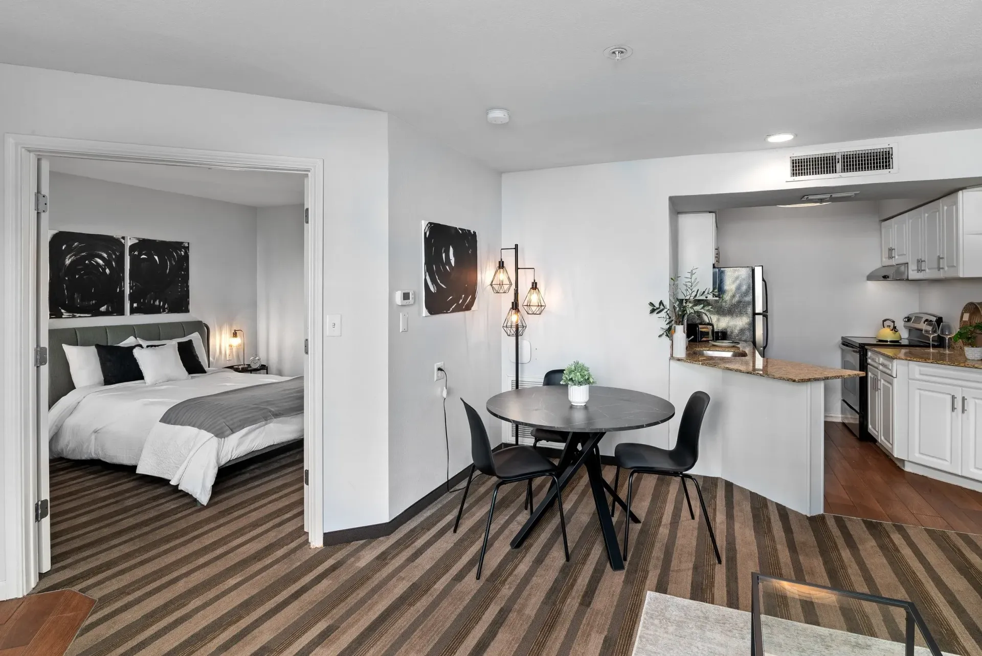 A bedroom with a bed and a table and chairs in it.