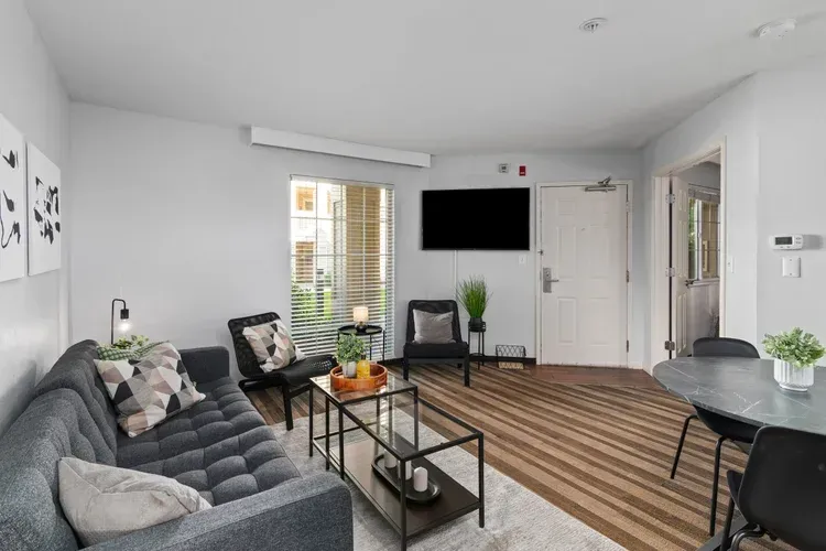 A living room with a couch , chairs , table and television.