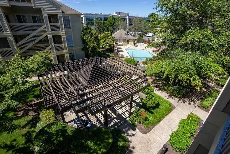 An aerial view of a building with a pergola and a pool