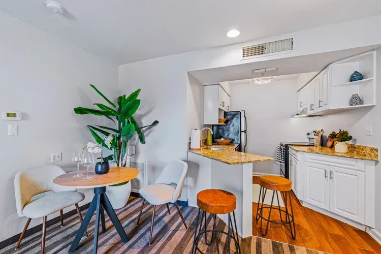 A kitchen and dining room in a small apartment with a table and chairs.