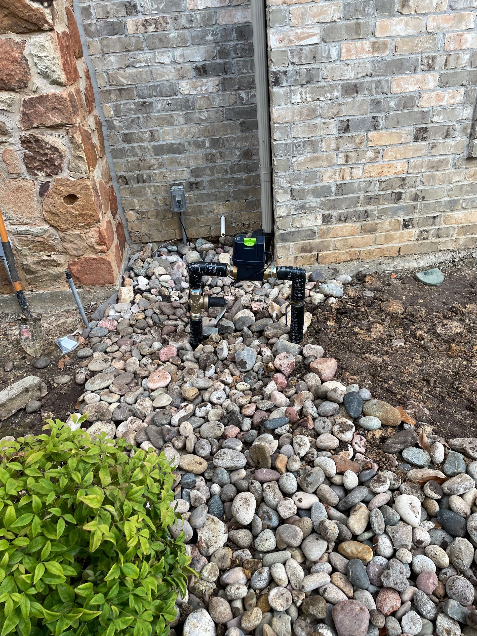 A pile of rocks in front of a brick wall.