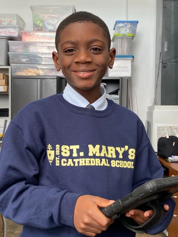A boy wearing a blue sweatshirt that says st mary 's cathedral school
