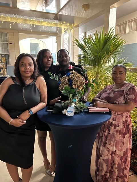 A group of people standing around a table with flowers on it.