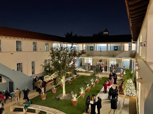 A group of people are standing in a courtyard at night.