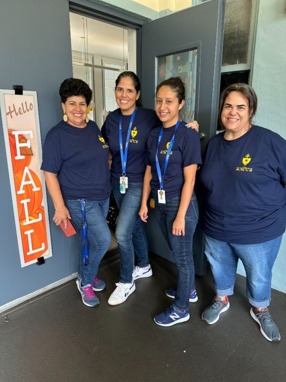 A group of women standing in front of a sign that says fall