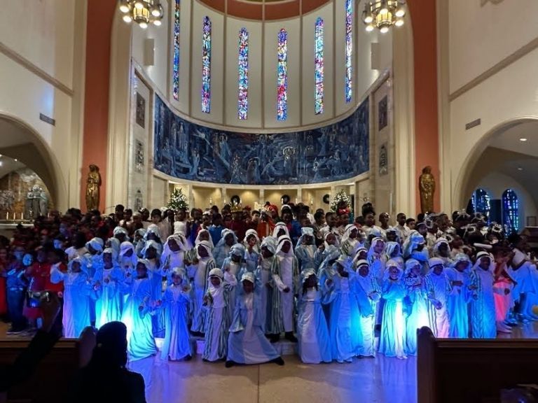 A large group of people are standing in a church.