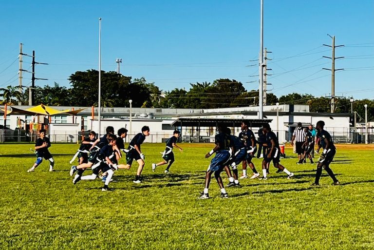 A group of football players are running on a field