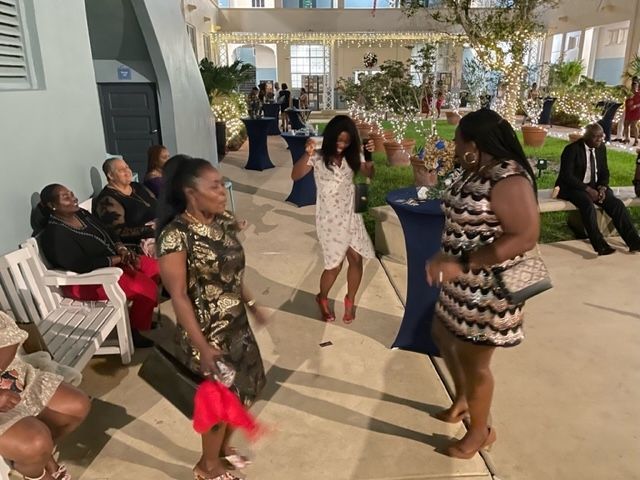 A group of women are dancing on a sidewalk in front of a building.