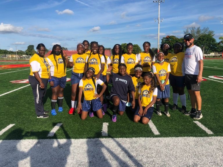 A group of people are posing for a picture on a field.