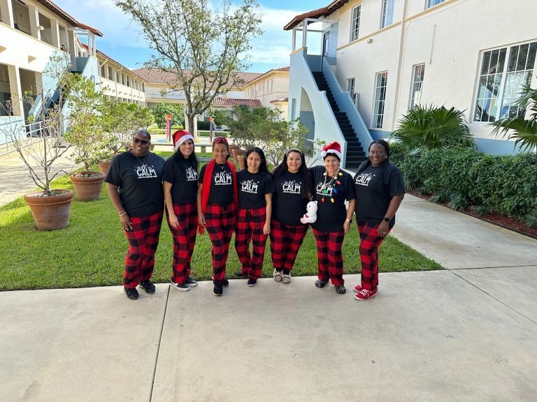 A group of people are posing for a picture in front of a building.