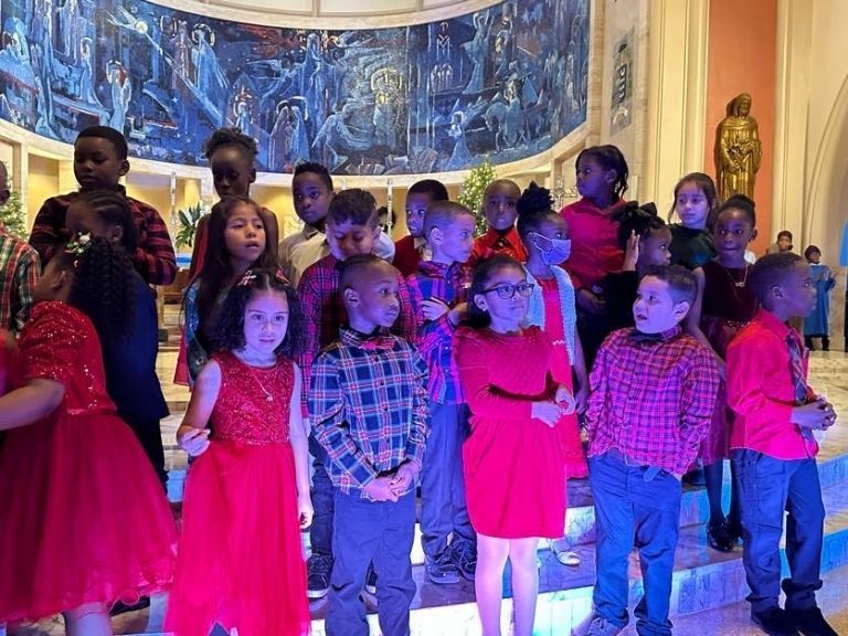 A group of children are standing next to each other in a room.