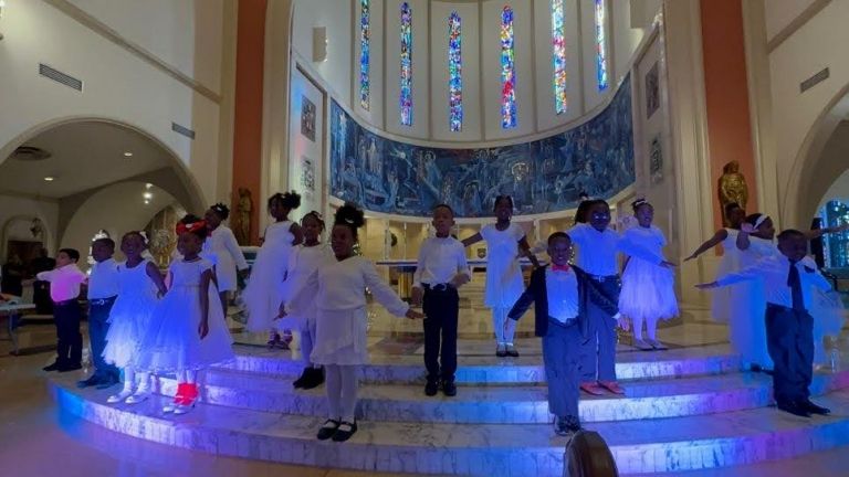 A group of children are standing on a stage in a church.