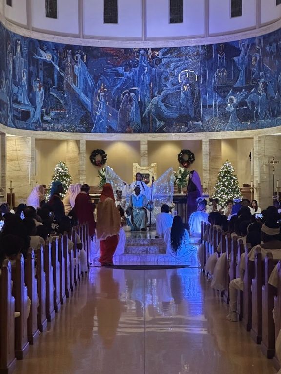 A group of people are standing in a church with christmas decorations