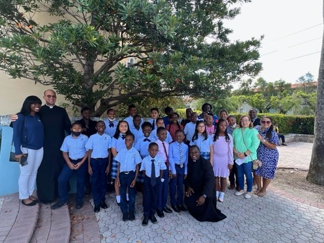 A group of people are posing for a picture in front of a tree.
