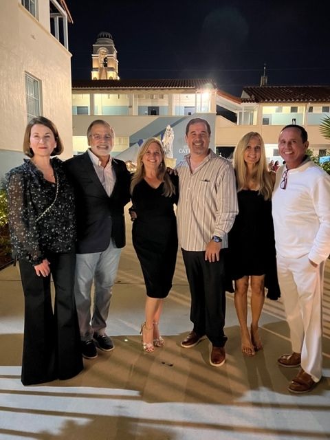 A group of people posing for a picture in front of a building at night