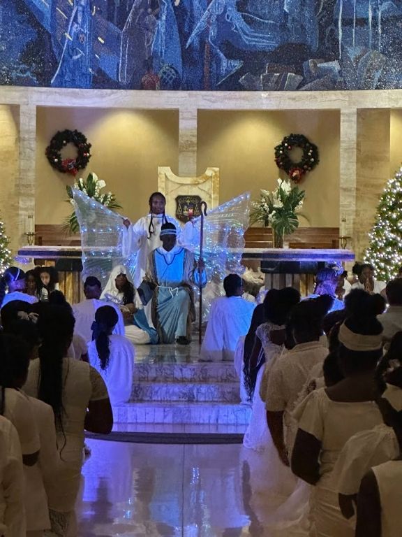 A group of people standing in front of a christmas tree in a church
