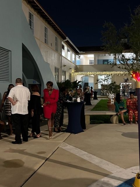 A group of people are standing outside of a building at night