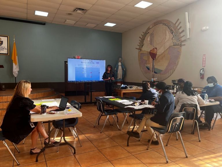 A woman is giving a presentation to a group of people