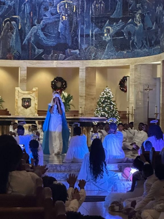 A group of people in a church with a christmas tree in the background