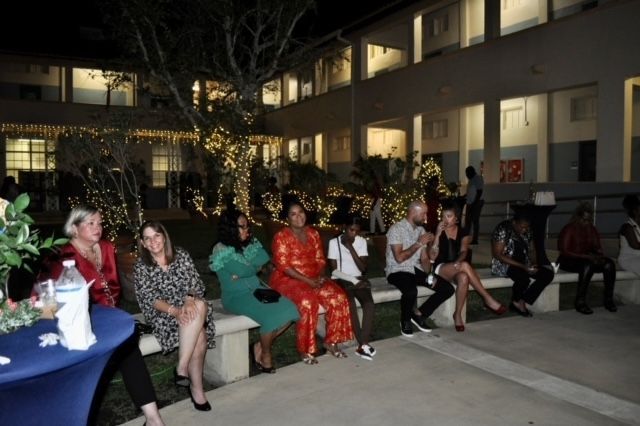A group of people are sitting on benches in front of a building