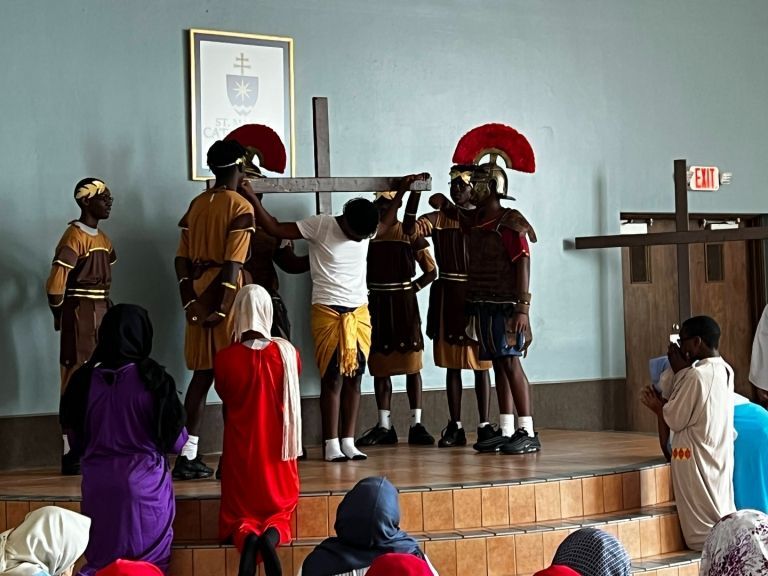 A group of people dressed as roman soldiers carrying a cross