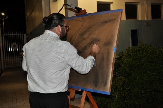 A man is painting a picture on an easel