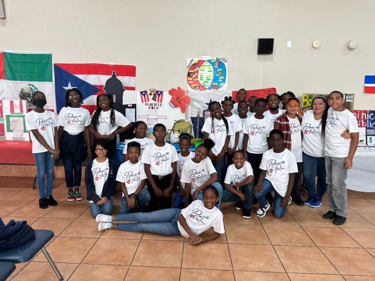 A group of children posing for a picture in front of flags