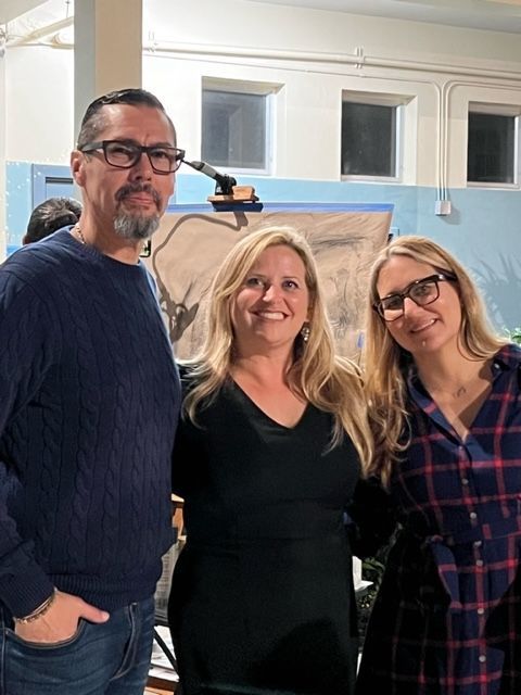 A man and two women are posing for a picture together