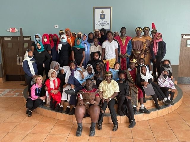 A group of people dressed in costumes are posing for a picture.