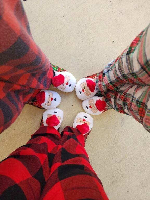 A group of people wearing santa claus slippers are standing in a circle