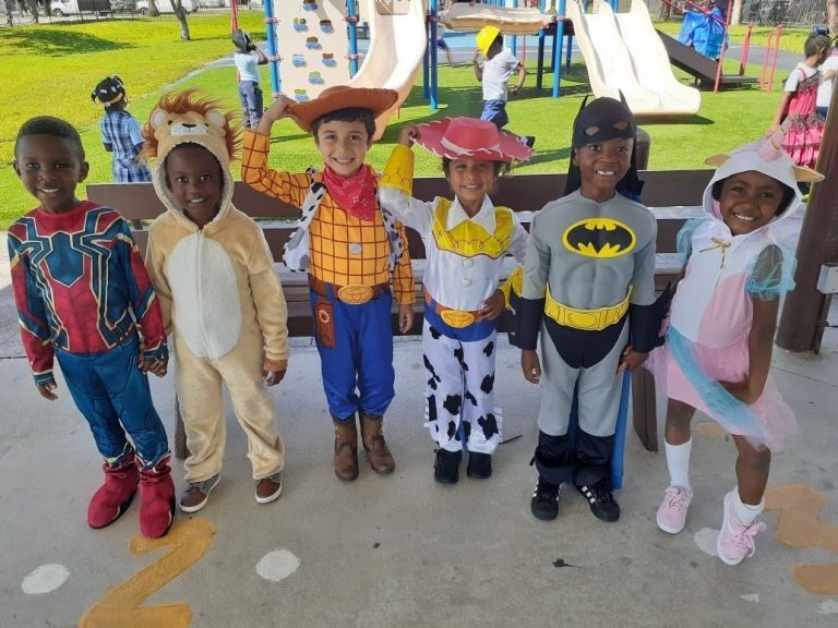 A group of children dressed in costumes are posing for a picture.