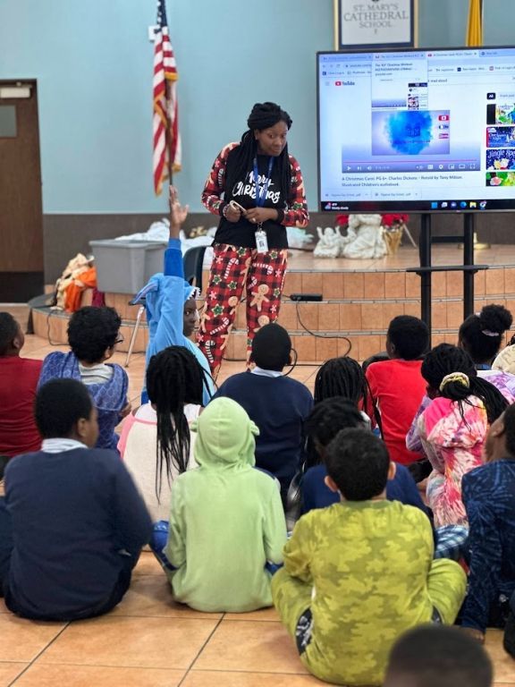 A woman is giving a presentation to a group of children