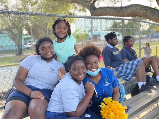 A group of young girls are sitting on a bench.