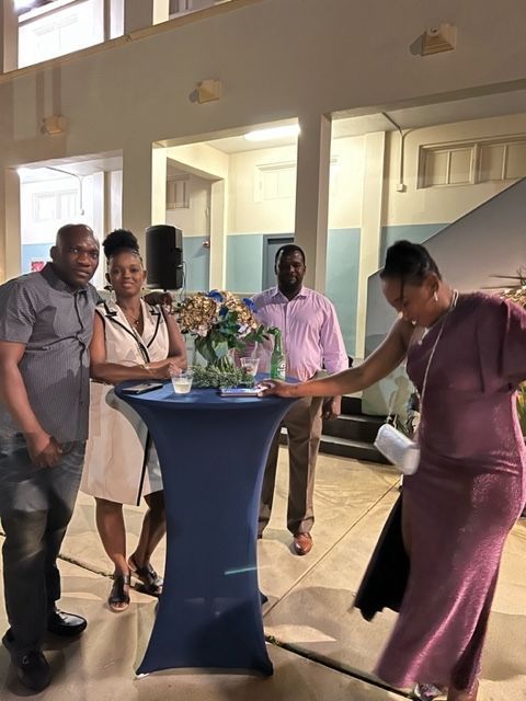 A group of people are standing around a table in a room.