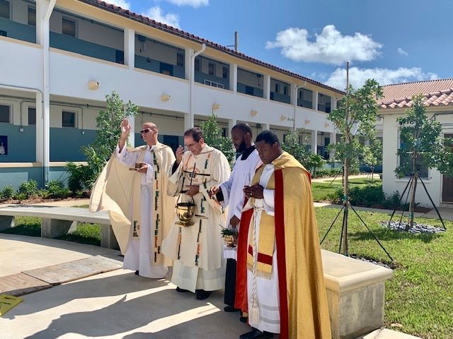 A group of priests are standing in front of a building