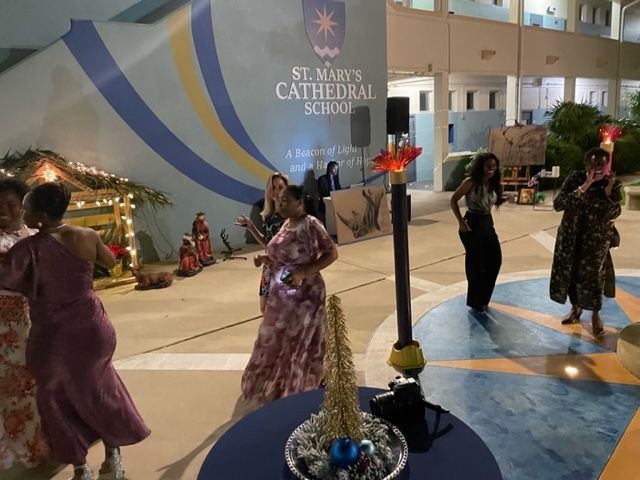 A group of women are dancing in front of a sign that says st. mary 's cathedral school